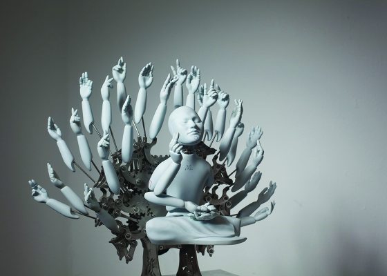 Grey and metallic sculpture of a robot in a meditation posture with many mechanical arms surrounding its body, artificial intelligence buddhism