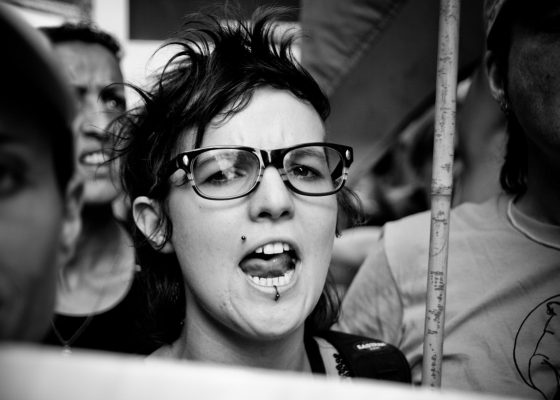 Girl looking at camera with angry face appearing to be shouting; anger in buddhism